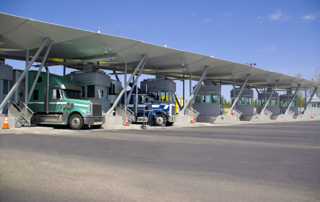 A semi truck passes through a border crossing.