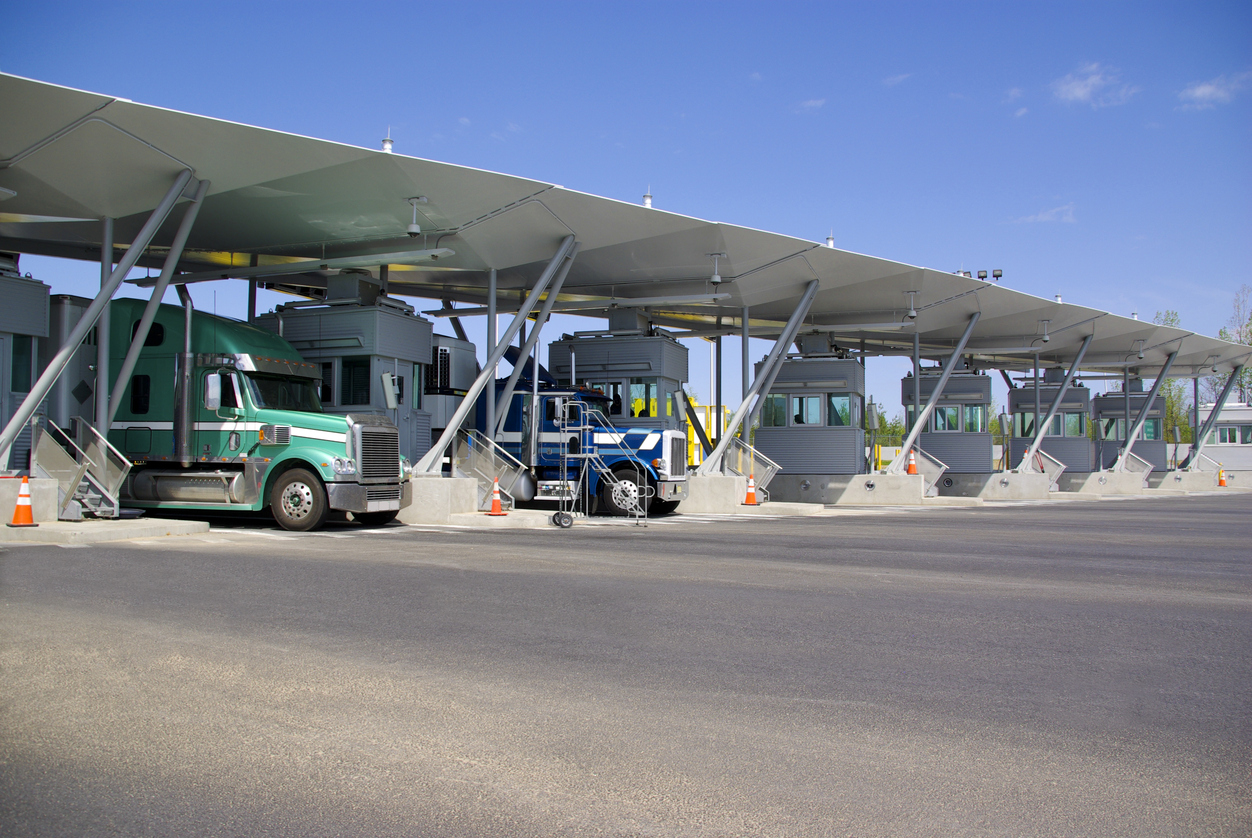 A semi truck passes through a border crossing.